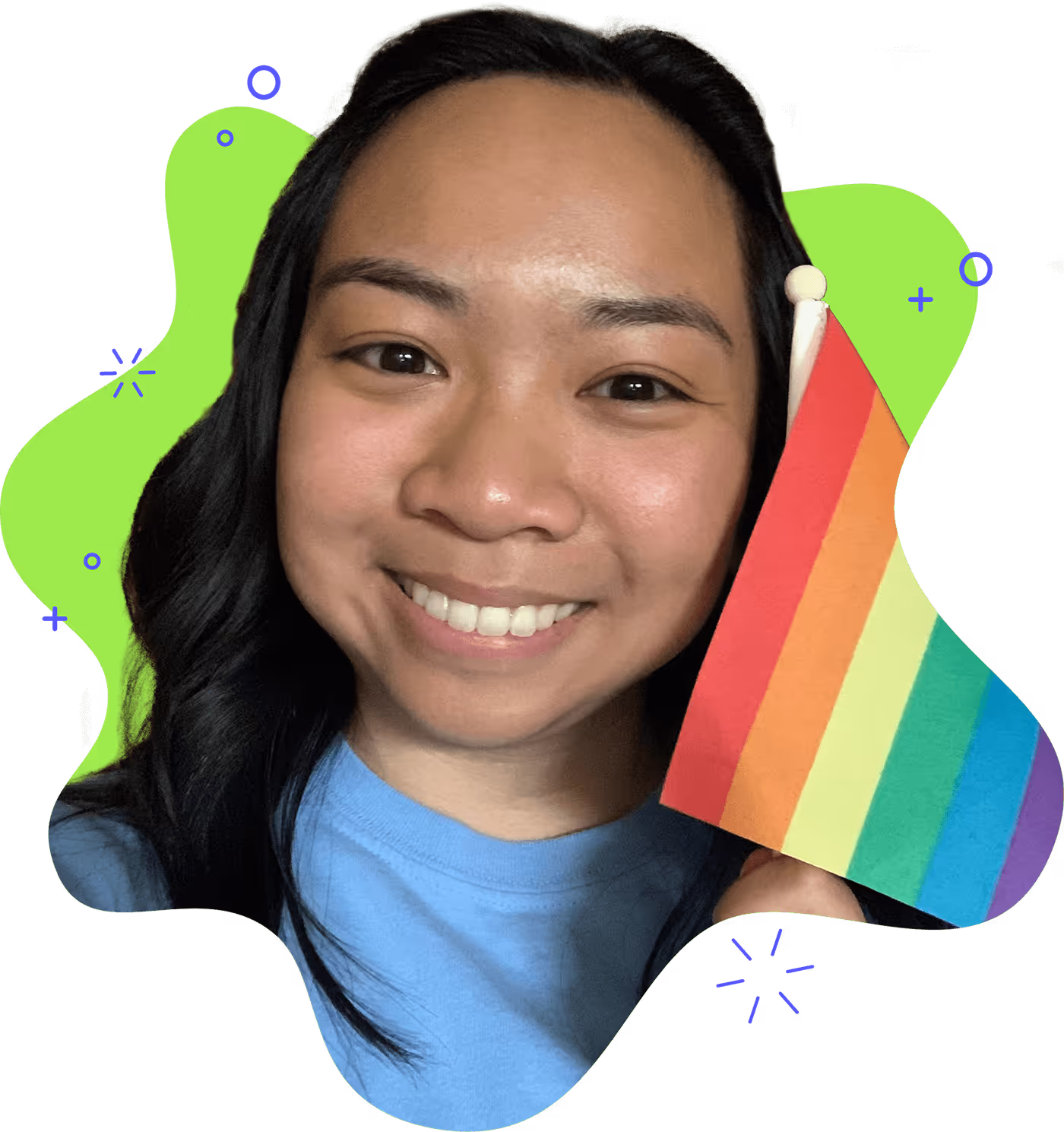 A smiling woman with a blue shirt and a rainbow flag.